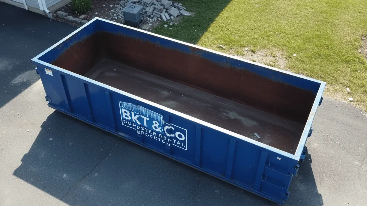 Basement and attic cleanouts in Brockton, Massachusetts — container beside a full-basement two-family house